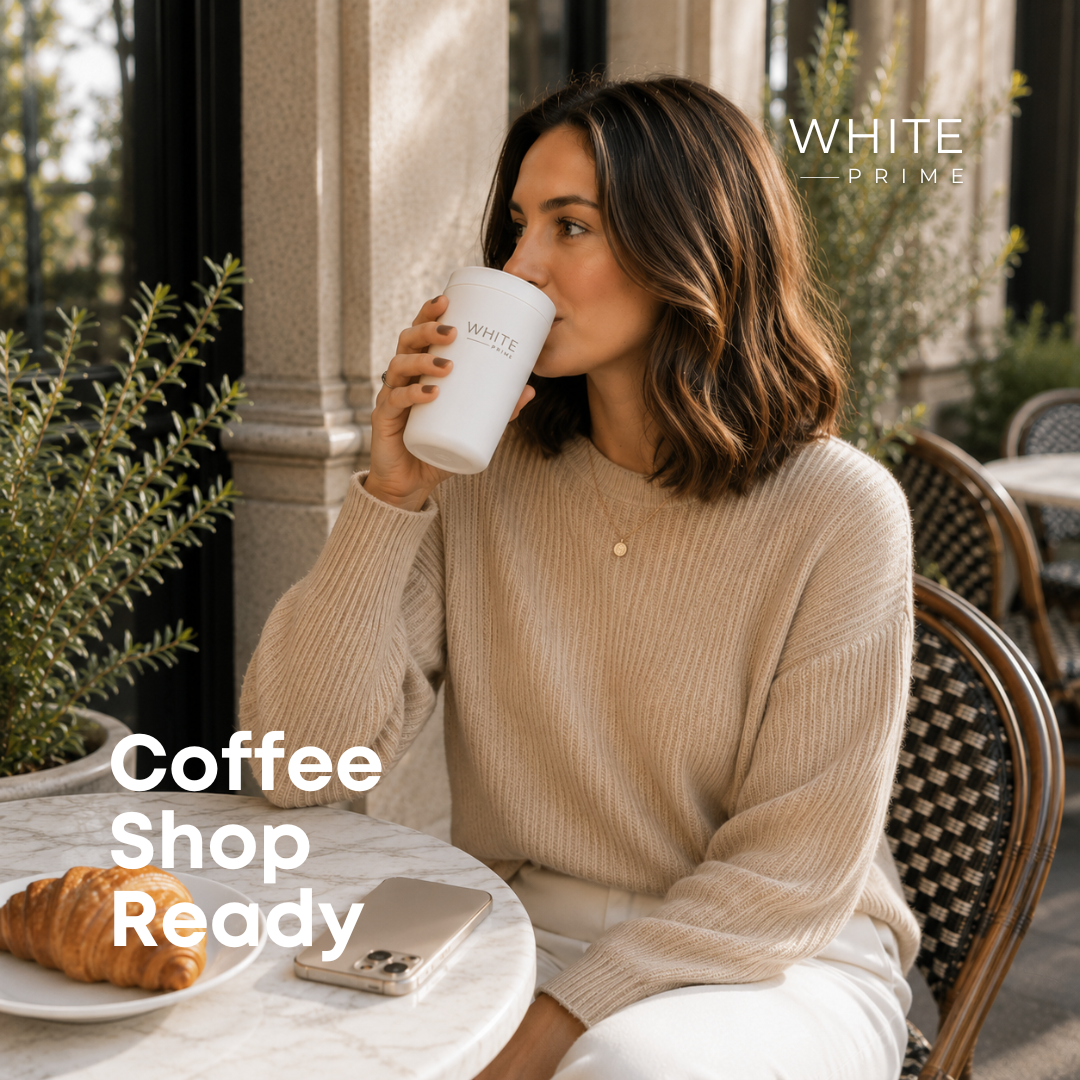 Woman enjoying coffee with the WHITE Prime insulated coffee mug at a café